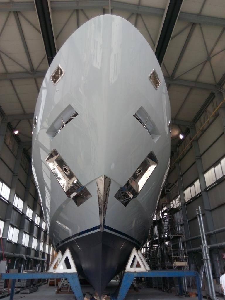 A large white boat is being built in a hangar
