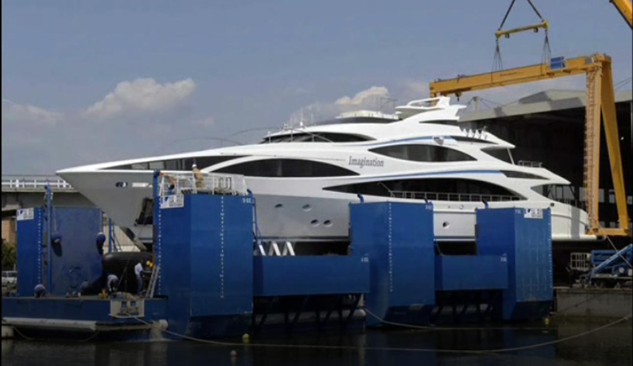 A large white yacht is being lifted by a crane