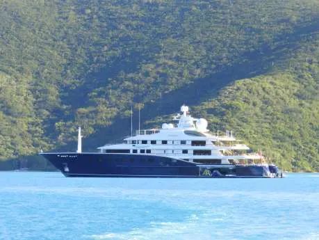 A large white yacht is floating on top of a body of water.