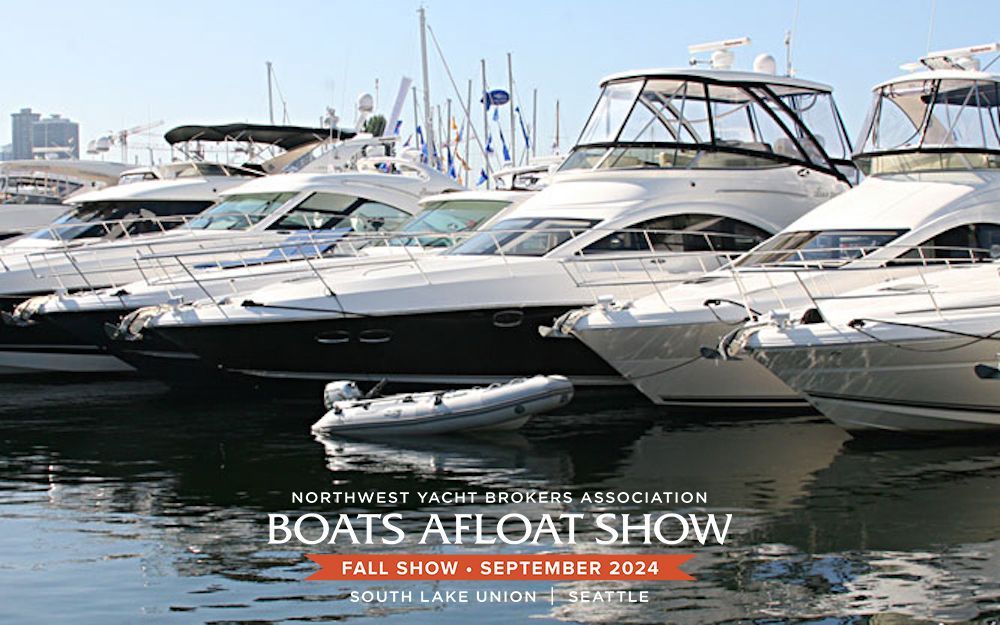 A row of boats are docked in a harbor.