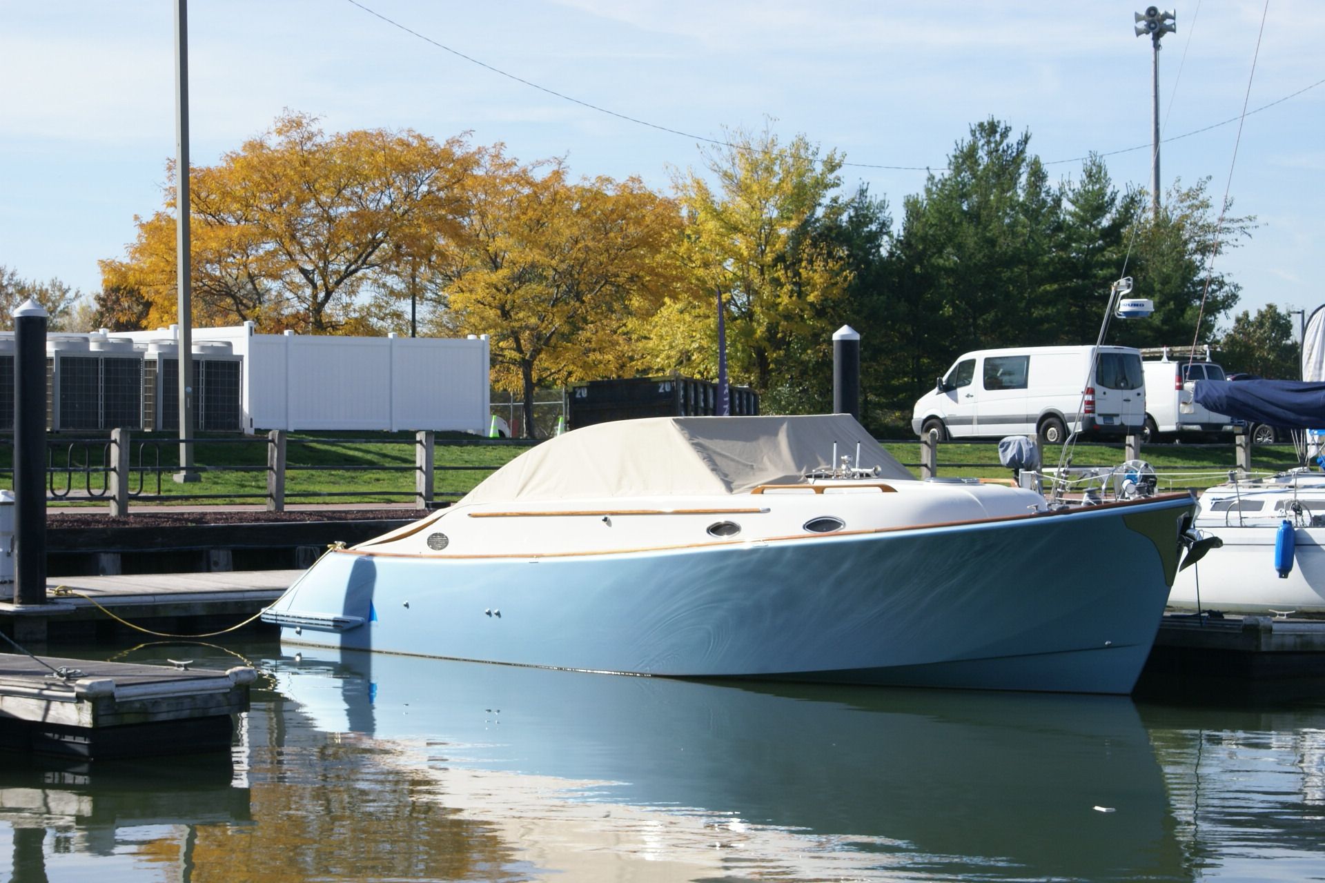 A blue and white boat is docked at a dock