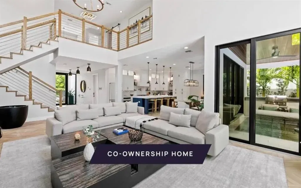 A living room with a couch , coffee table , and stairs.