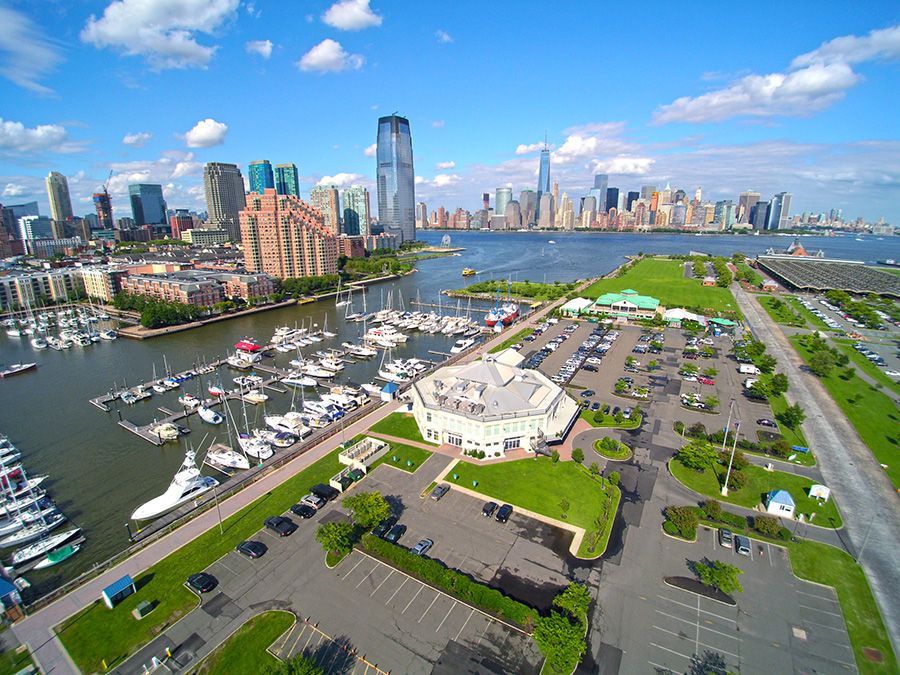 An aerial view of a marina with a city skyline in the background.