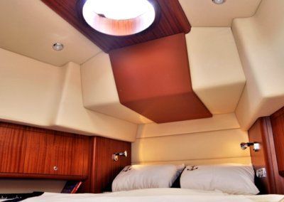 A bedroom with a bed and a ceiling light