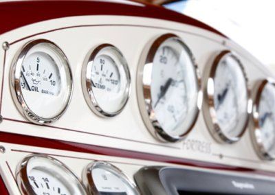 A close up of a boat dashboard with a few gauges including one that says oil