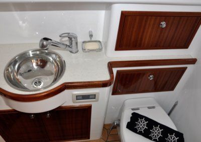 A bathroom with a sink and toilet on a boat.