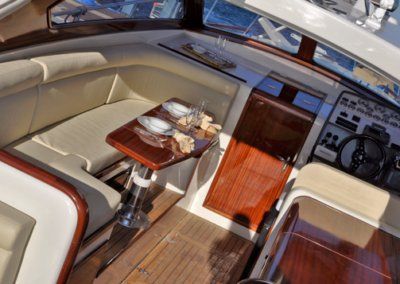 The inside of a boat with a table and a steering wheel