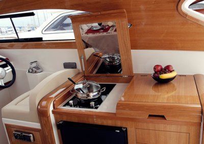 A kitchen on a boat with a pot on the stove