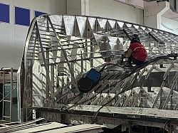 A man is sitting on top of a metal structure in a building.