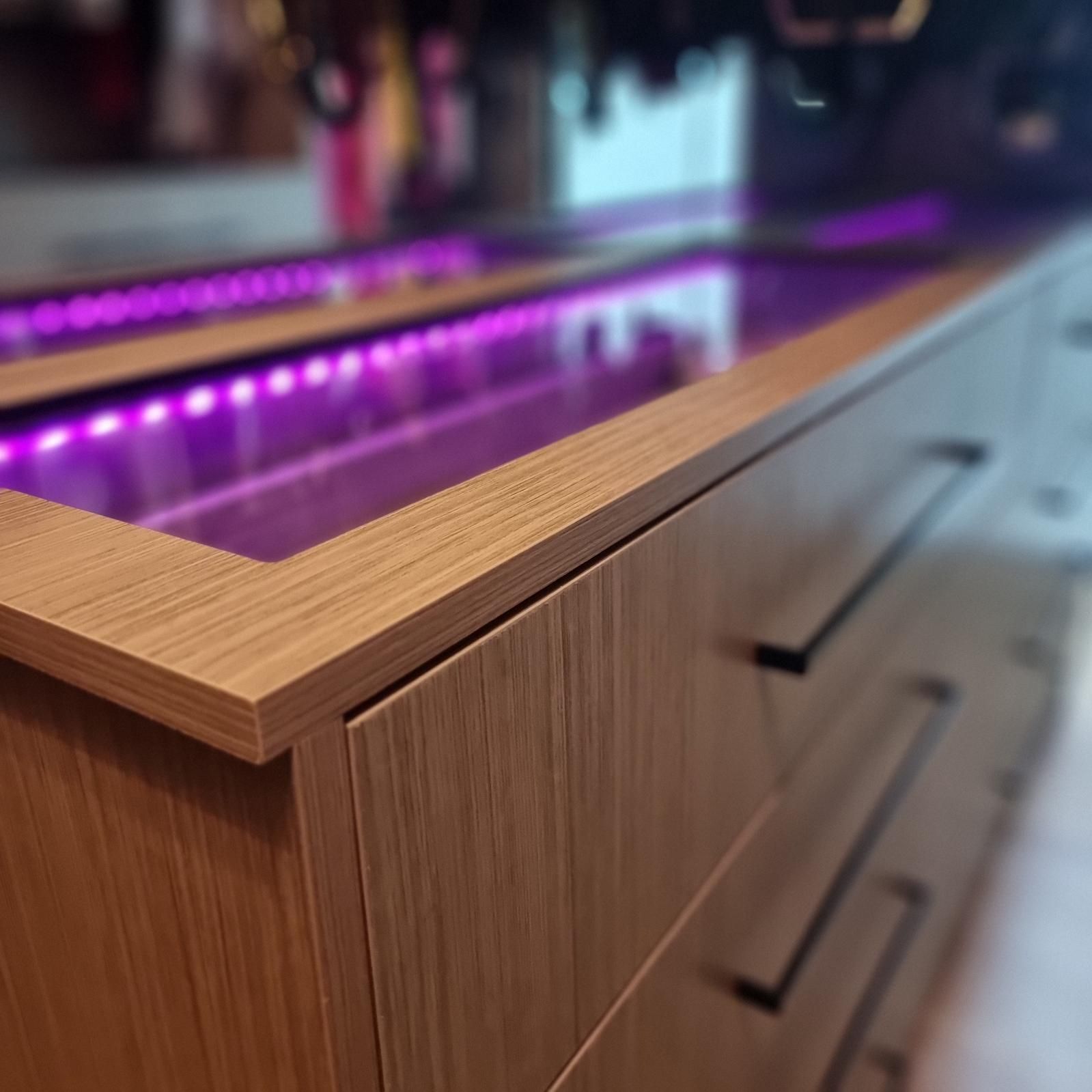 A Close up Of a Wooden Dresser with Purple Lights on It — Darko's Kitchens in Barrack Heights, NSW