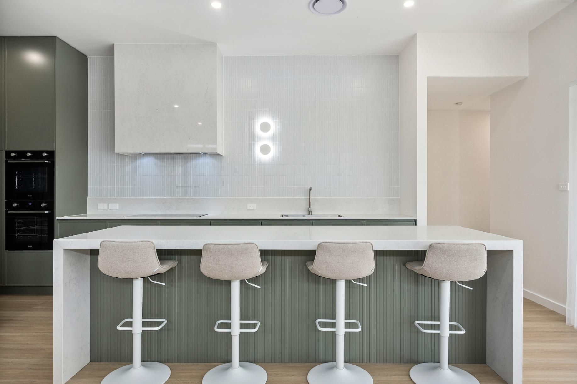 A Kitchen with A Large Island and Four Bar Stools — Darko's Kitchens in Horsely, NSW