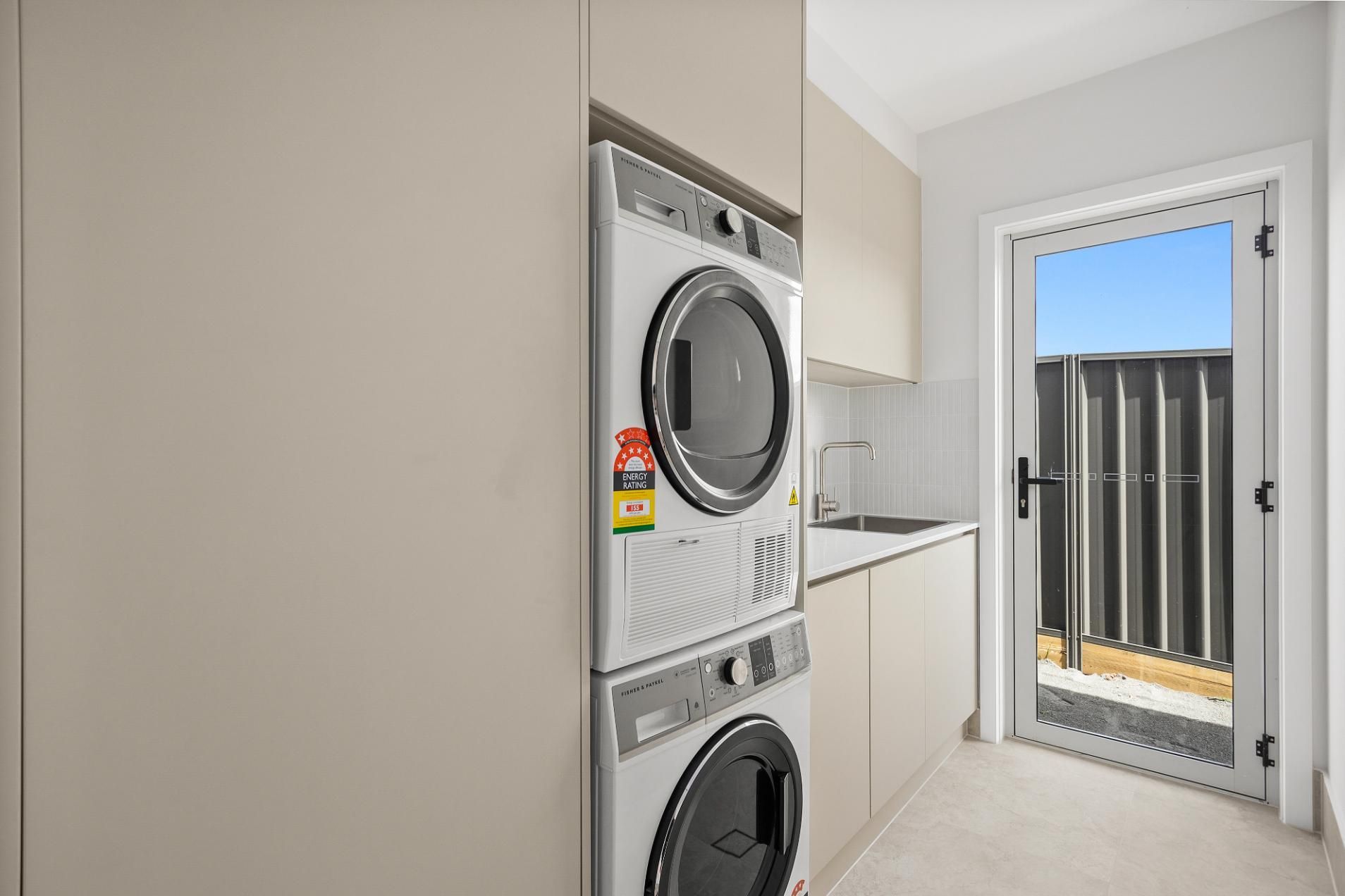 A Laundry Room with A Washer and Dryer Stacked on Top of Each Other — Darko's Kitchens in Horsely, NSW