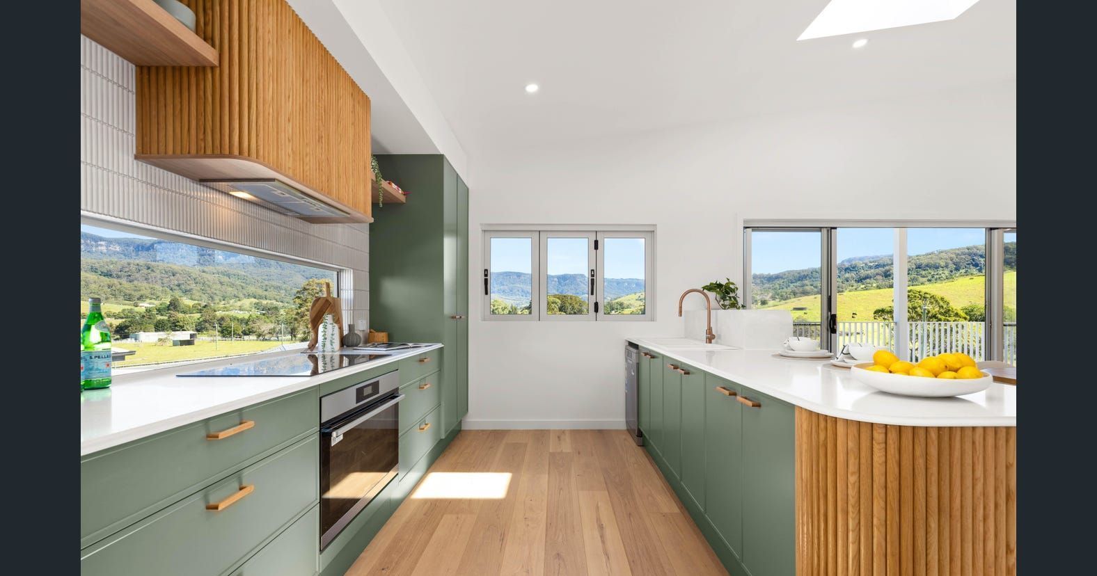 A Kitchen with Green Cabinets , White Counter Tops , and Wooden Floors — Darko's Kitchens in Calderwood, NSW
