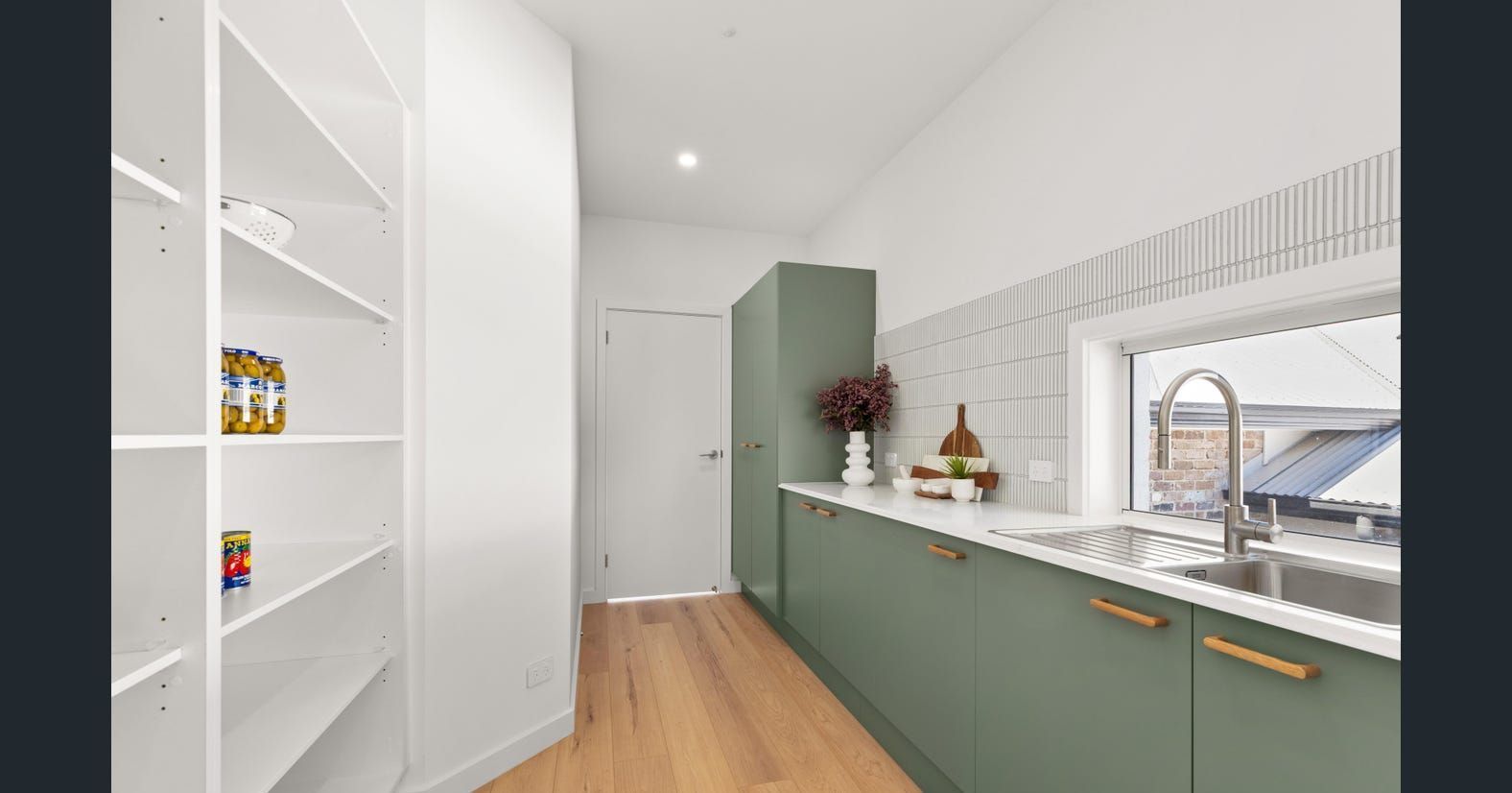 A Kitchen with Green Cabinets and White Shelves and A Sink — Darko's Kitchens in Calderwood, NSW
