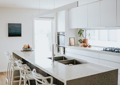 A Kitchen With White Cabinets, a Sink, and a Sliding Glass Door — Darko's Kitchens in Kiama, NSW