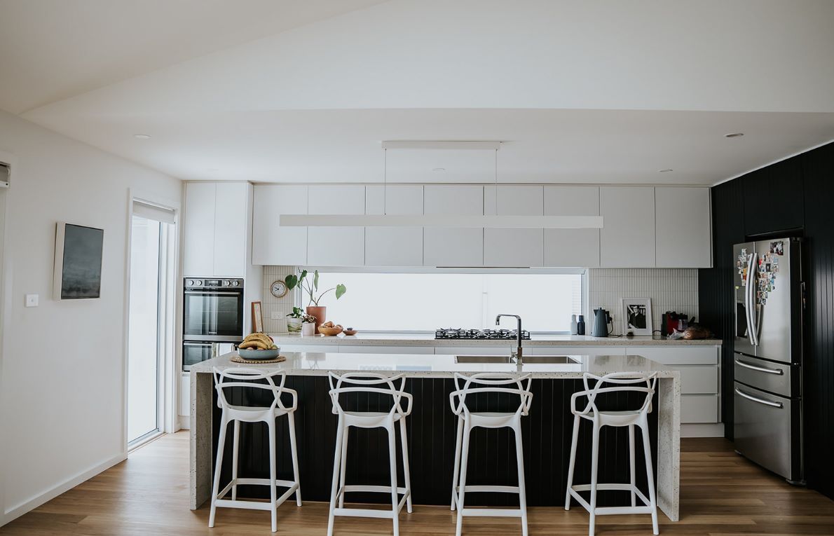 A Kitchen With a Large Island , Stools and a Refrigerator — Darko's Kitchens in Kiama, NSW