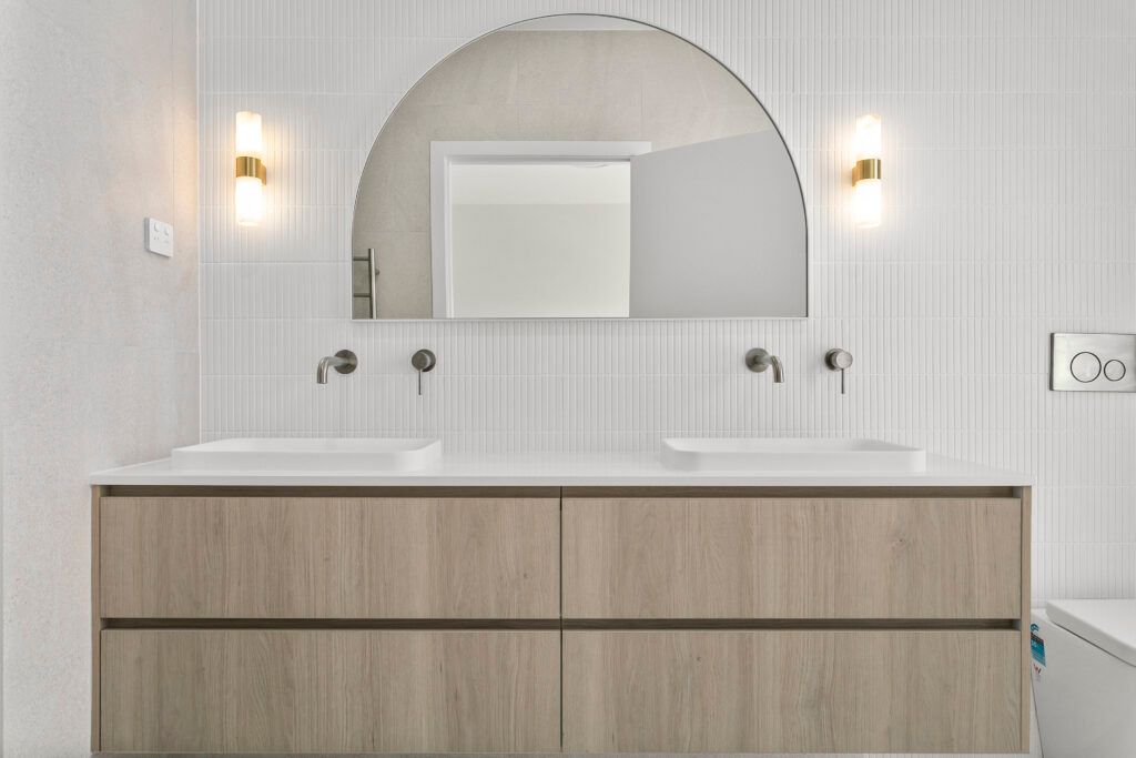 A Kitchen With a Large Island and Wicker Stools — Darko's Kitchens in Primbee, NSW