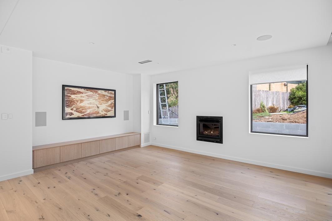 A Living Room With Hardwood Floors, Stairs , and a Fireplace — Darko's Kitchens in Woonona, NSW