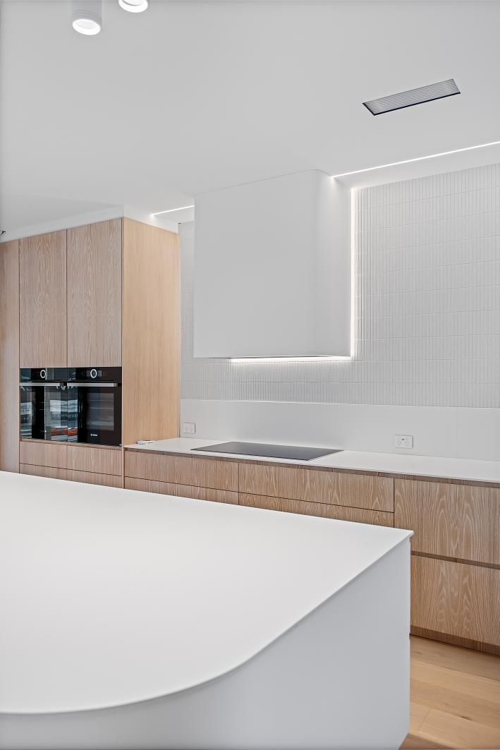 An Empty Living Room With Hardwood Floors— Darko's Kitchens in Woonona, NSW