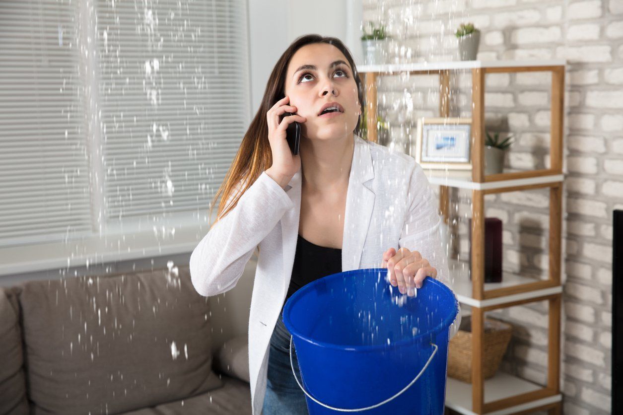 a woman is holding a blue bucket and talking on a cell phone .