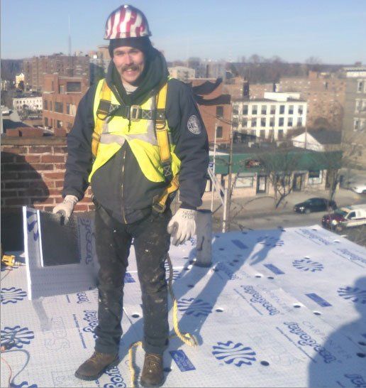 Roofer with a helmet on a roof