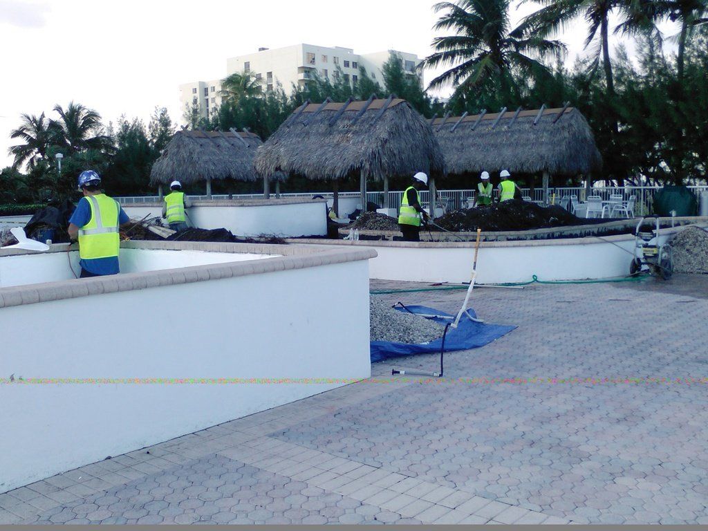 a group of construction workers are working on a pool