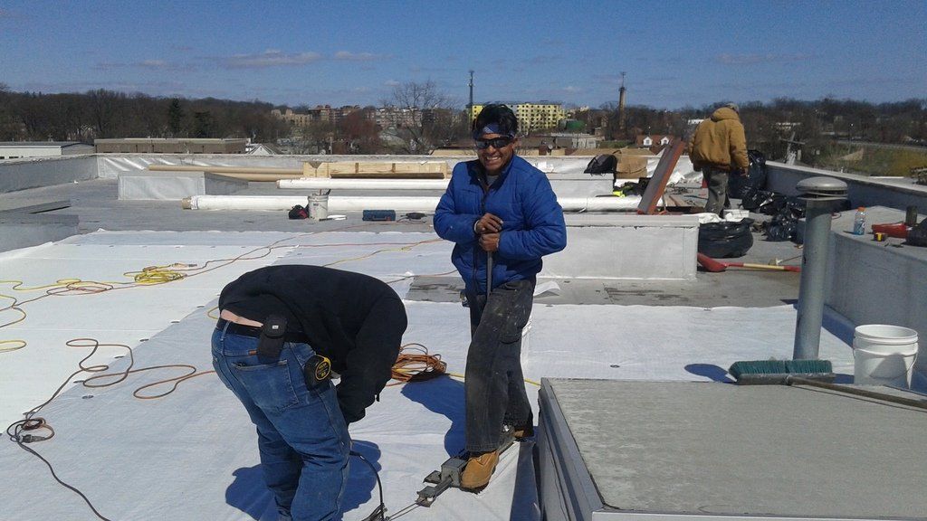 two men are working on the roof of a building