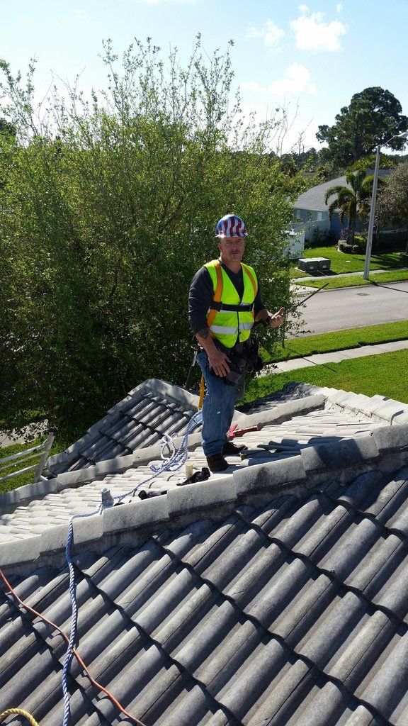 a man is standing on top of a tiled roof .