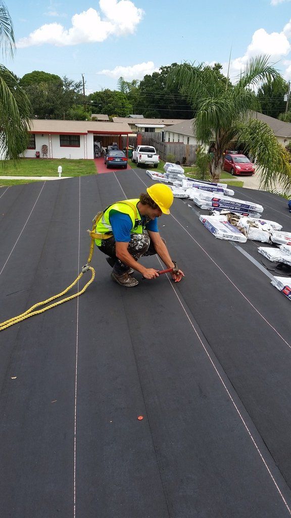 a man in a hard hat is working on a roof .