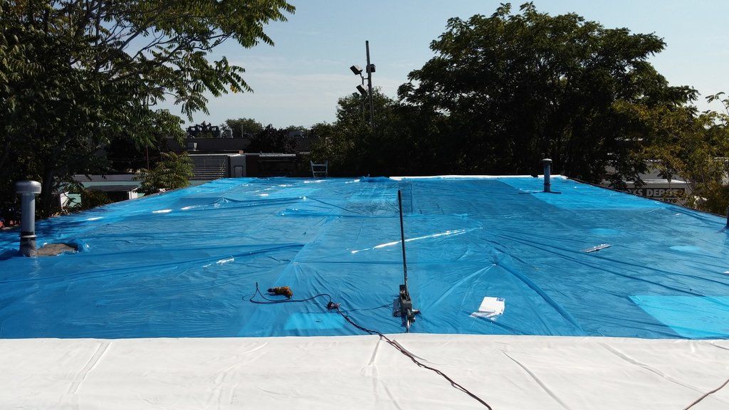 a blue tarp is covering the roof of a building .