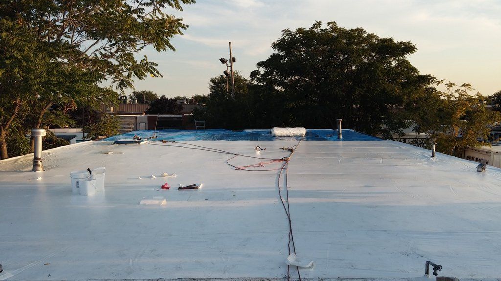 a large white roof with trees in the background .