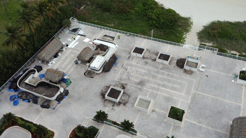 an aerial view of a rooftop area with tables and chairs .