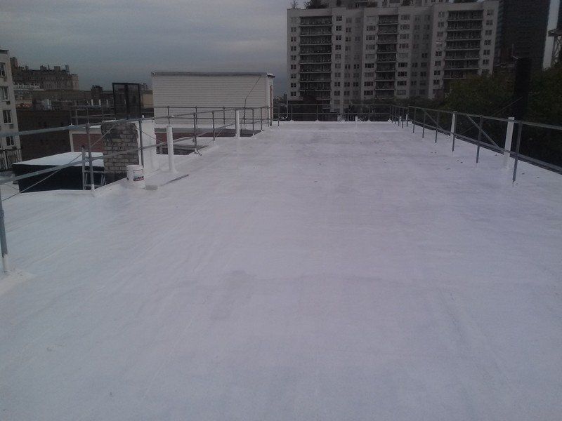 a white roof with a railing on it and a building in the background .