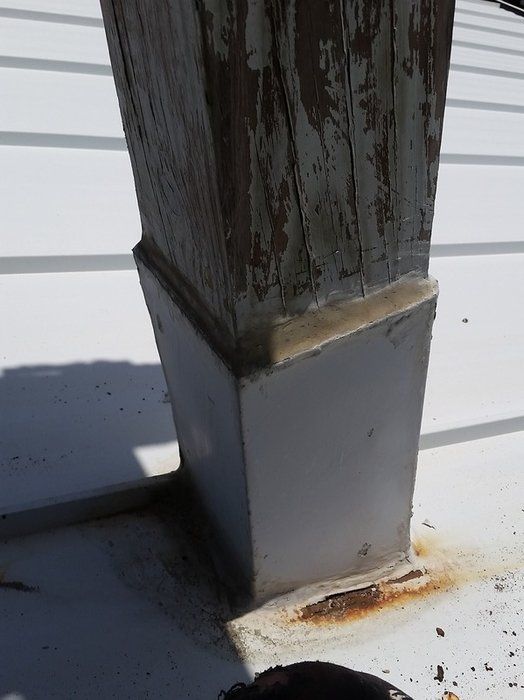 a wooden post is sitting on top of a white roof .