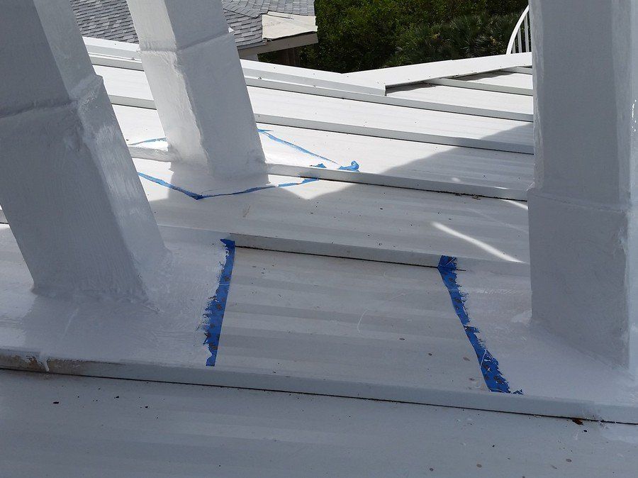 a white railing with blue tape on it is being painted