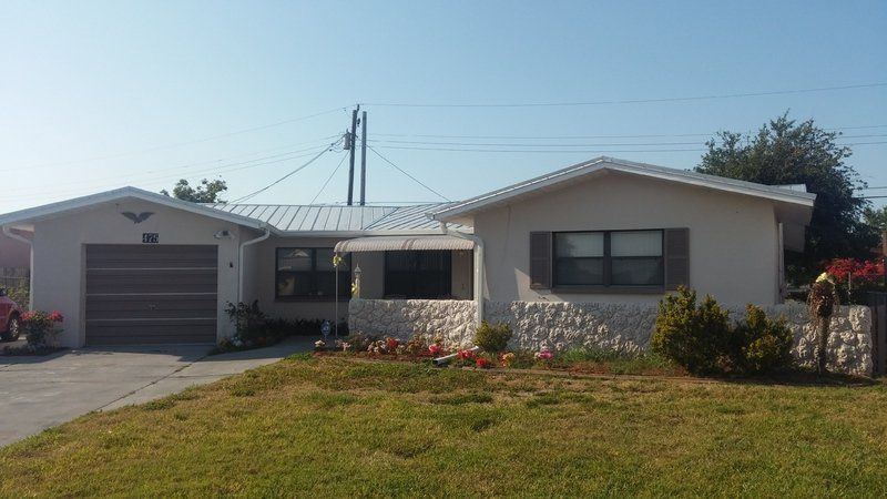 a white house with a garage and a car parked in front of it .