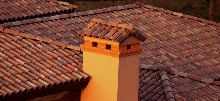 a chimney is sitting on top of a tiled roof .