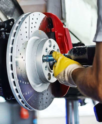 Mechanic working on brake disc | Gregg & Jim's Services