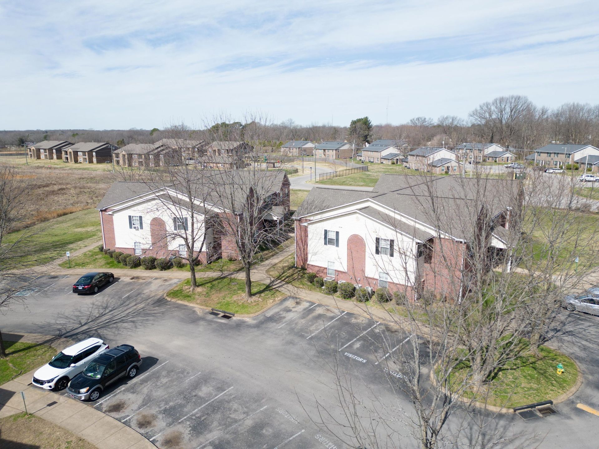 An aerial view of a residential area with houses and a parking lot.