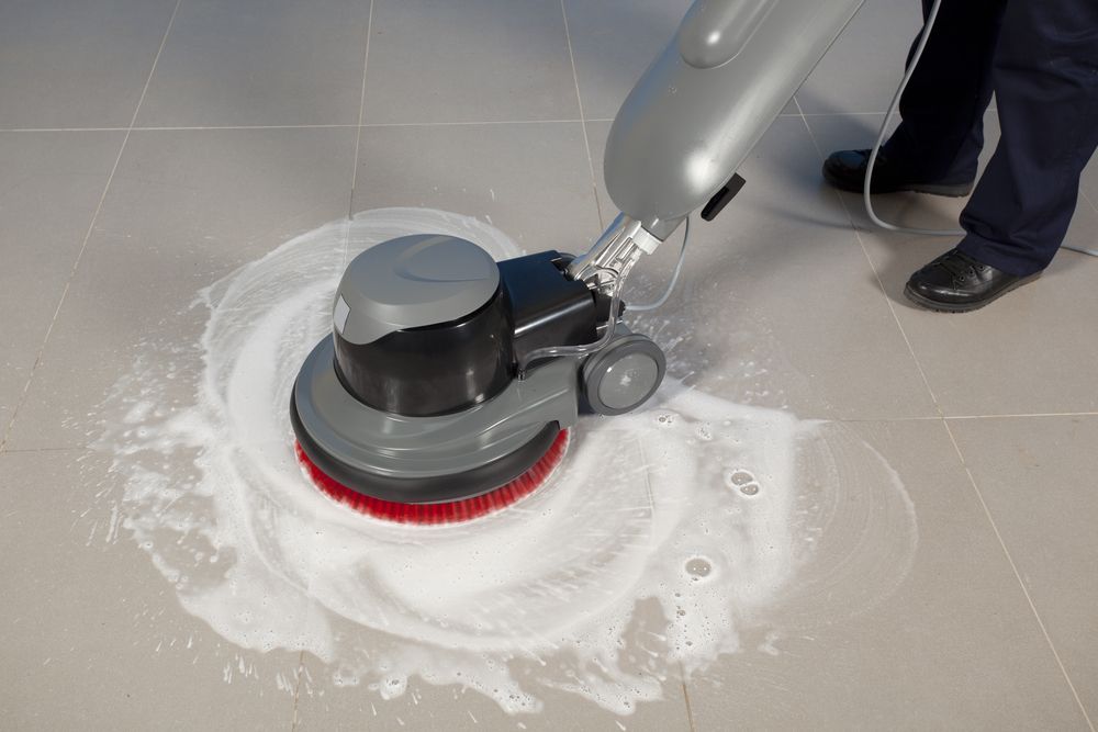 Floor Cleaner Scrubbing a Tile Floor With Foam — Integral Cleaning Services in Hunter Valley, NSW