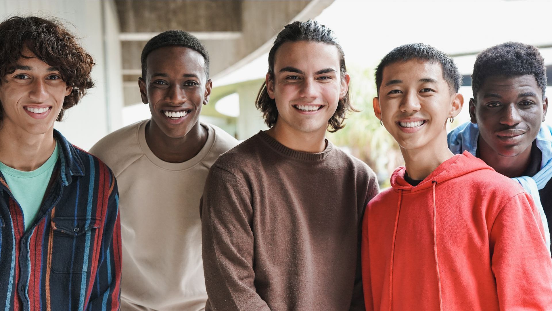 A group of young men are posing for a picture together and smiling.