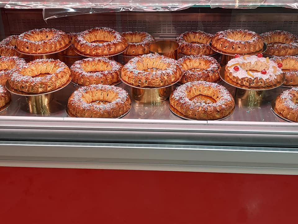 Una vetrina piena di una varietà di pasticcini ricoperti di zucchero a velo.