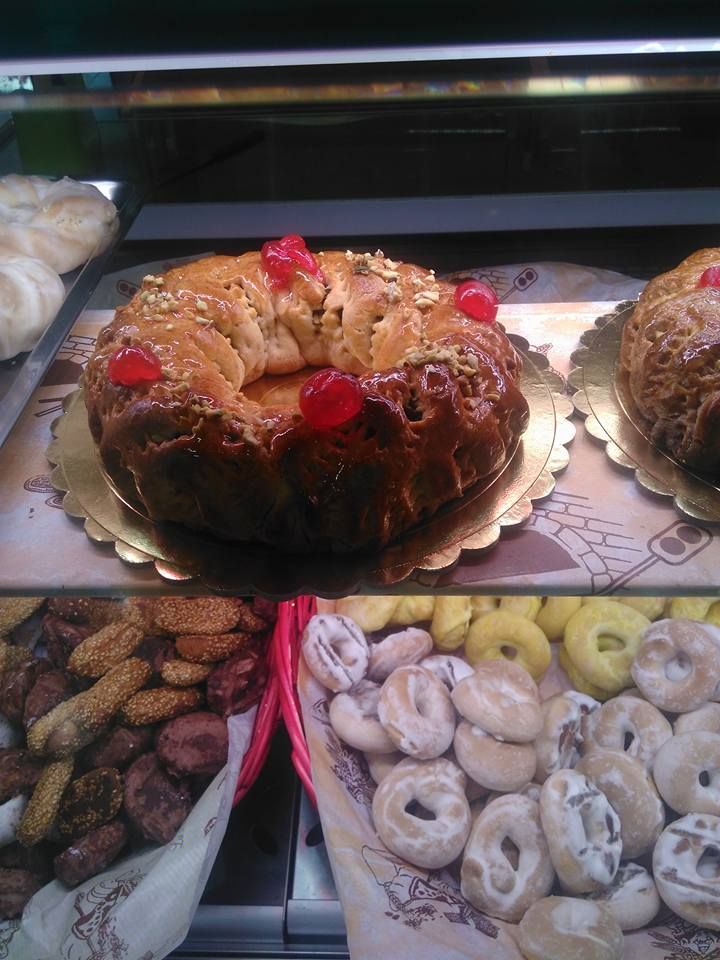 Una torta con sopra le ciliegie è posata sopra un vassoio di biscotti.