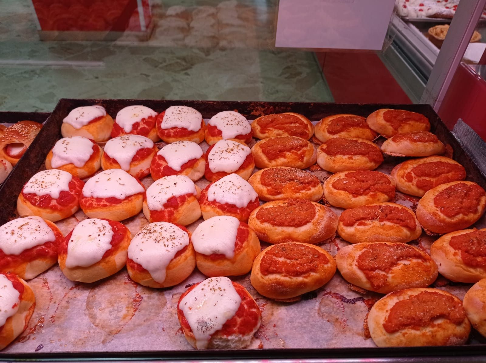 Un vassoio di pizze con salsa di pomodoro e formaggio sopra