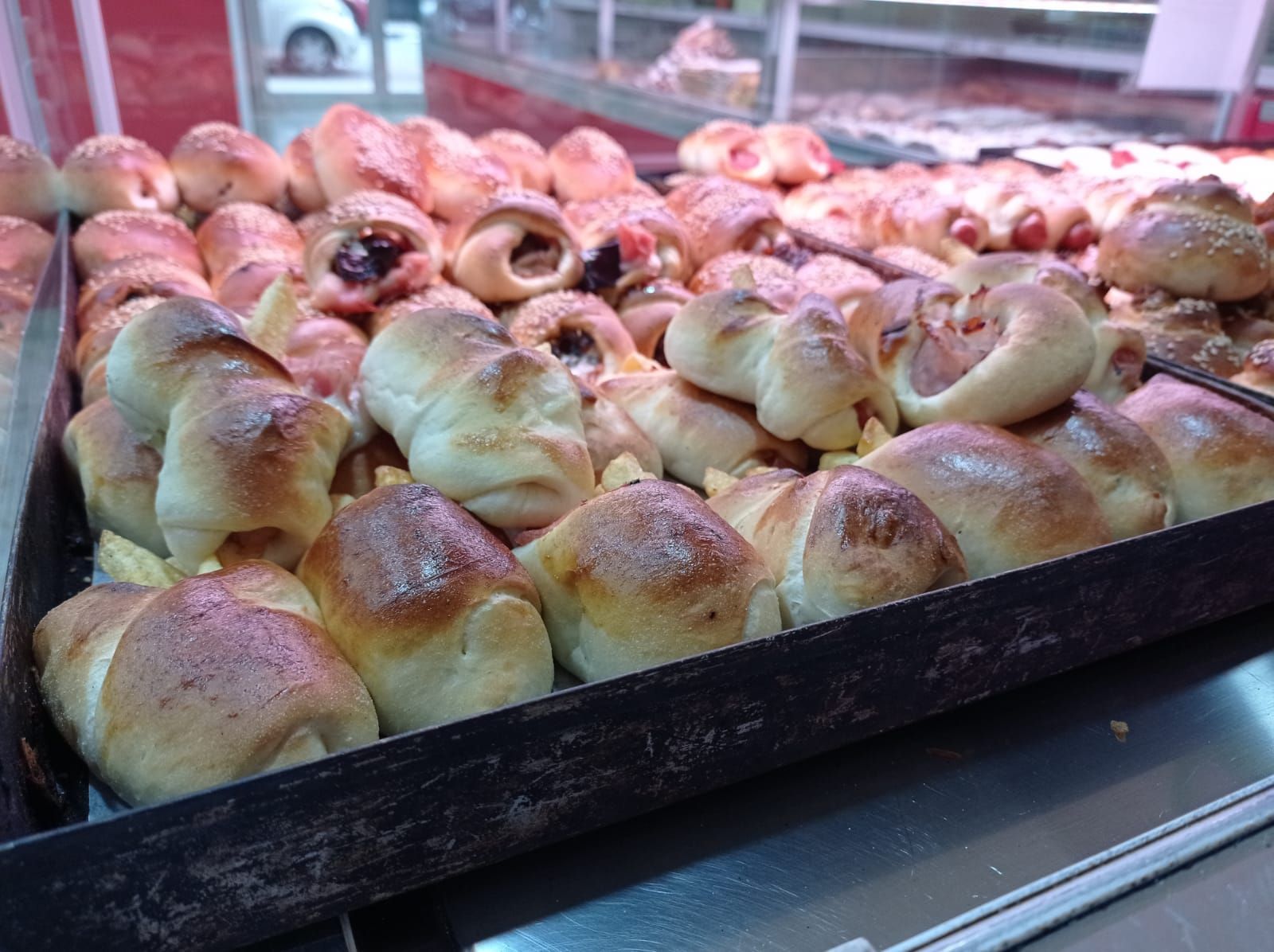Sul bancone di una panetteria c'è un vassoio di pasticcini.