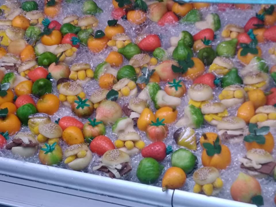 Una varietà di frutta e verdura viene esposta sul ghiaccio