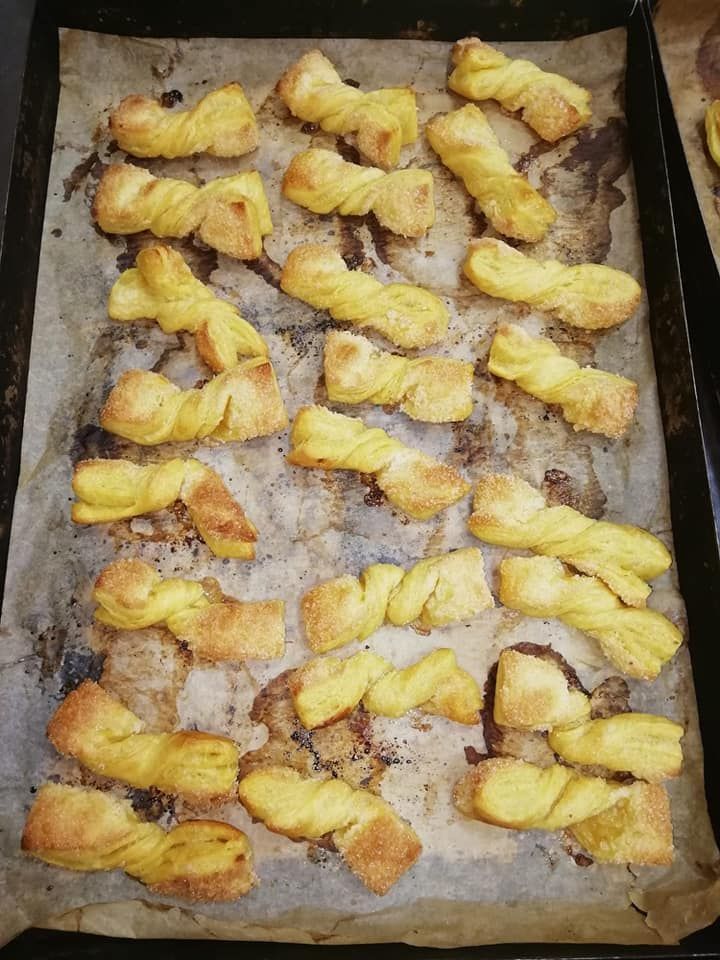 Un vassoio di bastoncini di pasta attorcigliati su un pezzo di carta oleata.