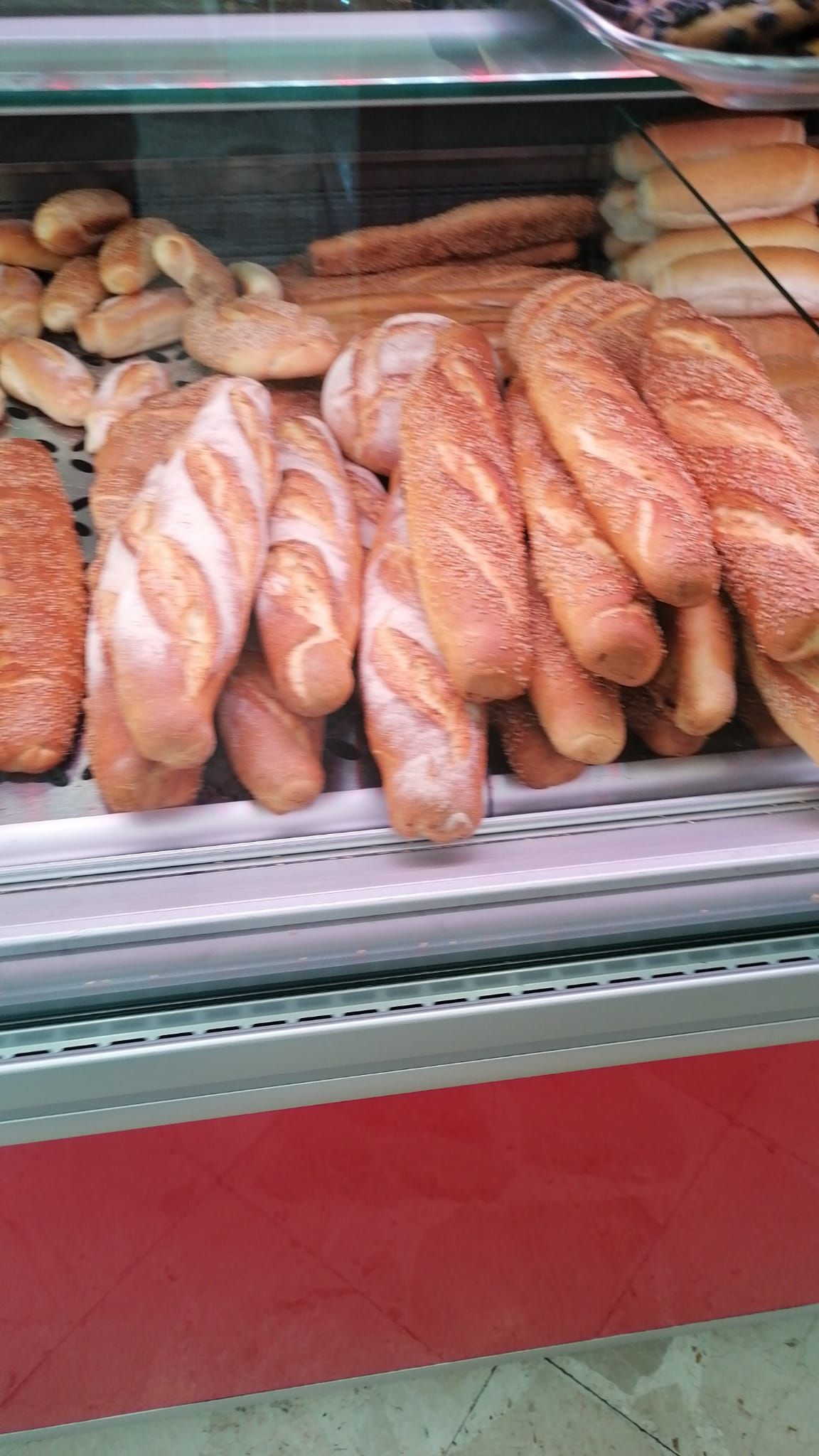 Una vetrina piena di tanti tipi diversi di pane.