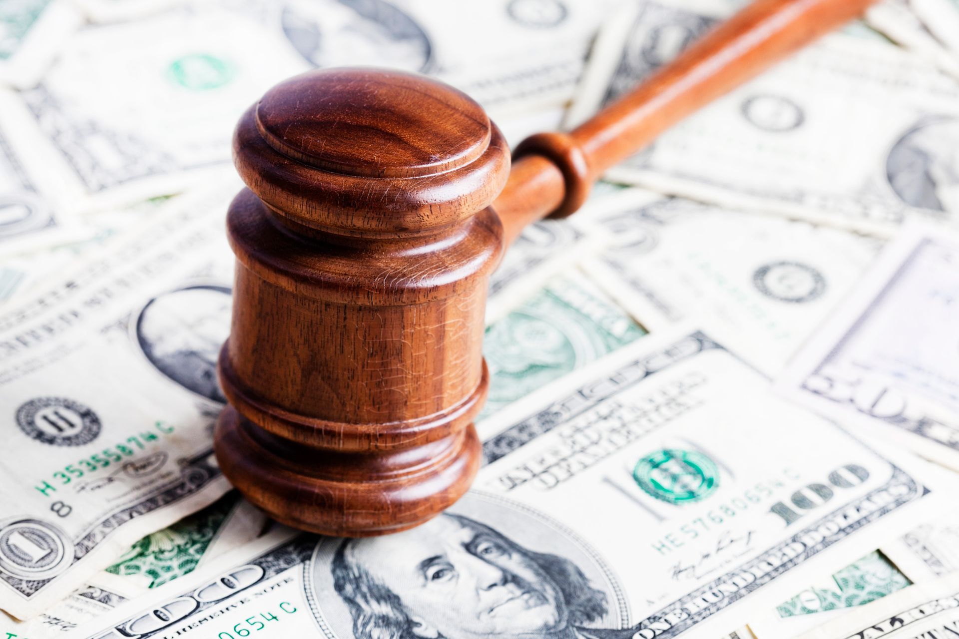 Gavel on Pile of US Dollars — Decatur, GA — DeWoskin Law Firm