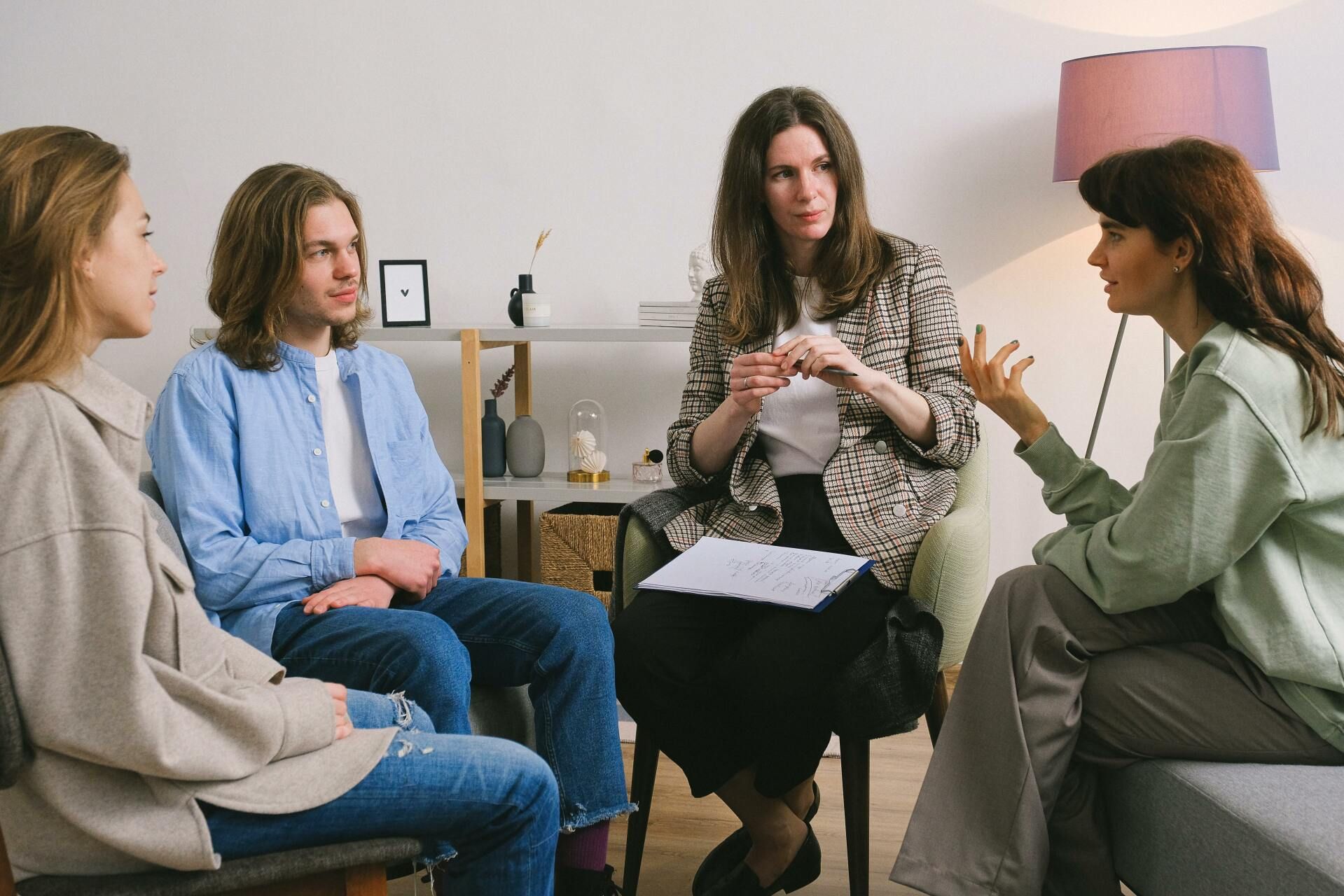 A group of people are sitting in a circle talking to each other.
